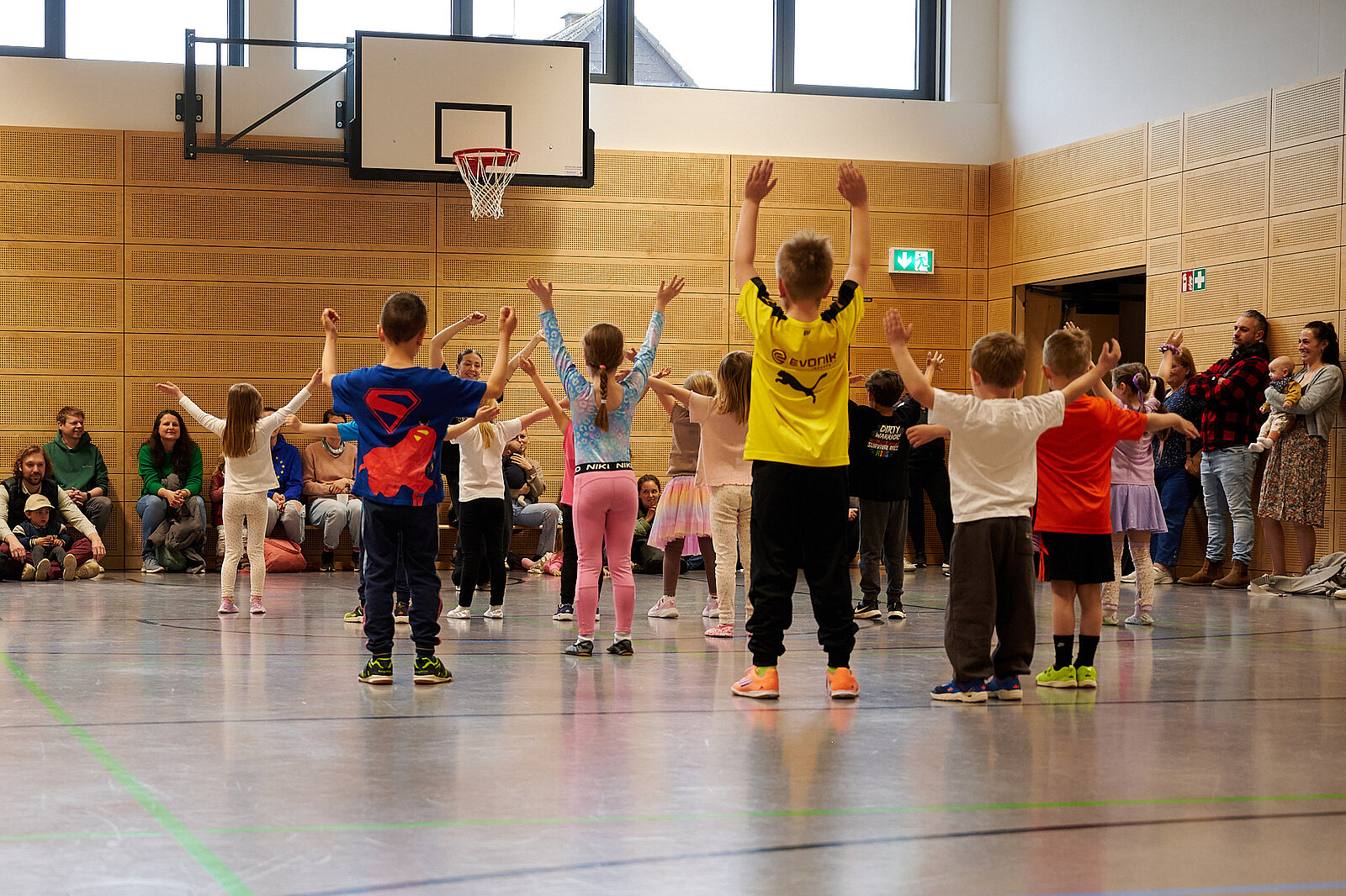  Kids tanzen und springen und Eltern sind Zuschauer