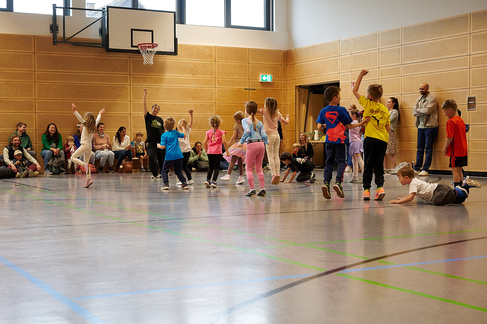  Kids tanzen und springen und Eltern sind Zuschauer